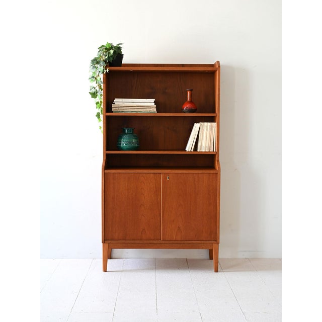 Elegant 1950s teak bookcase, with three open shelves and a compartment closed by hinged doors. Vintage Scandinavian teak...