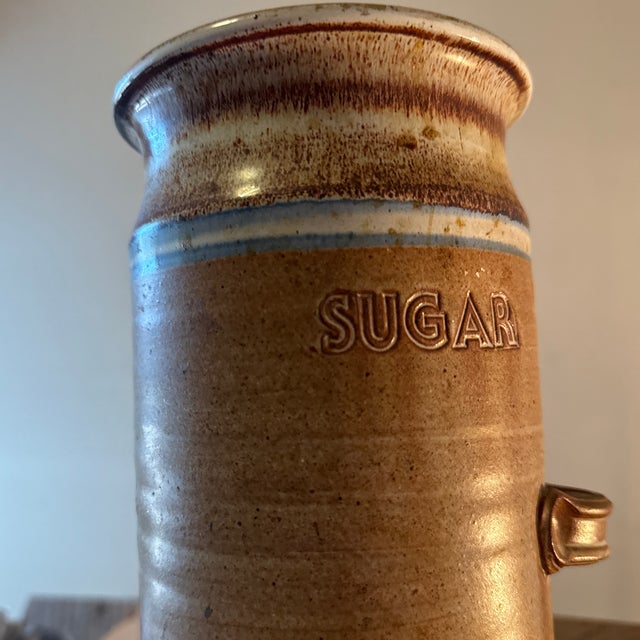 A charming handcrafted pottery sugar jar featuring a natural cork lid, blending rustic warmth with practical design. The...