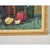 Dimensions: 25” H x 28 ⅜” W x 2” D A midcentury modern still-life painting of assorted bottles and fruit on a fabric-...