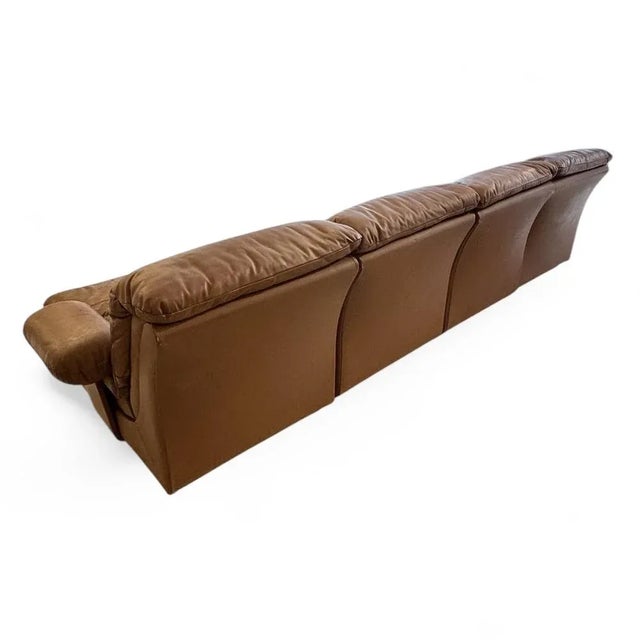 A striking example of 1970s Italian design, this 4-piece modular sofa is upholstered in rich cognac leather with a...