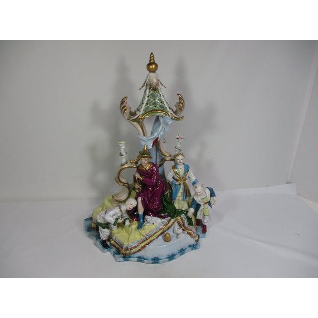Monumental German porcelain hand-painted figural group. It depicts a seated male figure with a dog laying at his feet and...