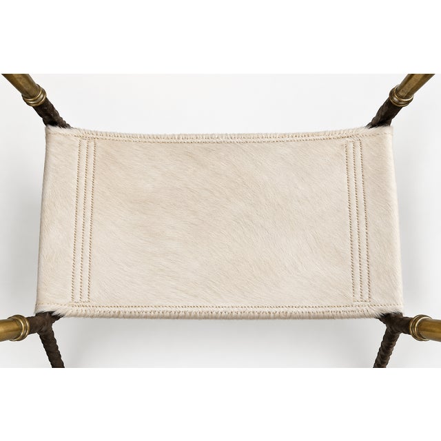 This distinctive footstool features a hand-forged twisted iron frame with decorative floral rosette details and warm aged...