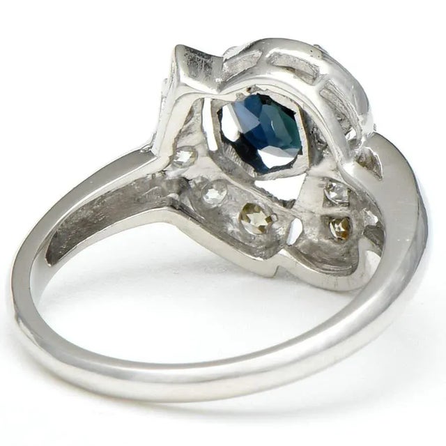 Cool platinum and brilliant diamond clusters encase a stunning sapphire that appears to hold all the mysteries of the...
