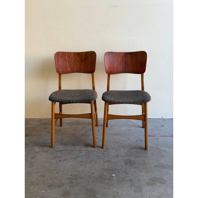 Elegant pair of Danish Modern dining chairs designed by Ib Kofod-Larsen for Christensen & Larsen, produced in Denmark...