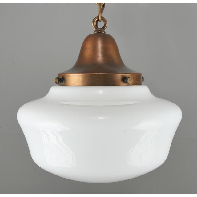 Antique Schoolhouse style pendant light with an antique milk glass globe paired with a newly made patina brass chain...