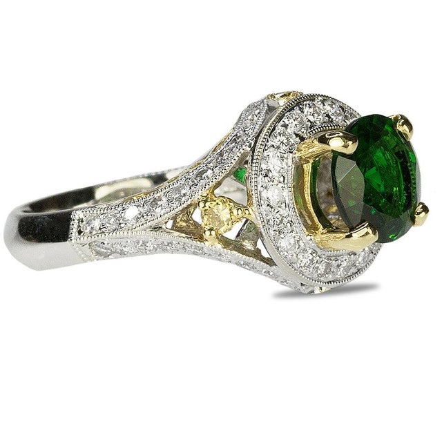 18k Ring set with 1 round chrome tourmaline weighing 1.40 carats and yellow and white diamonds weighing 0.84 carats. 6.36...