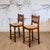 These Spanish style 60s/70s oak bar stools have rush seats. They were likely produced in Romania.