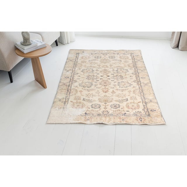 This is a vintage Turkish Oushak rug from the Mid 20th Century. The piece was hand-knotted.