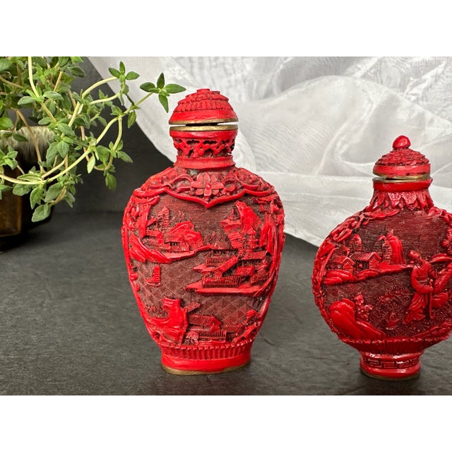 These antique Chinese cinnabar snuff bottles have delicate and intricately carved landscape scenes on each side. The...