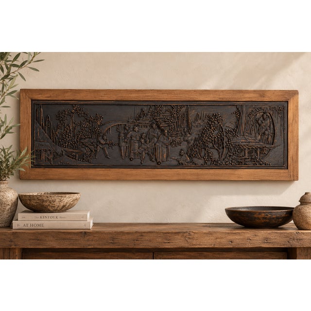 A courtyard gathering carved in high relief and finished in distressed black, with coppery wear on the raised surfaces. A...