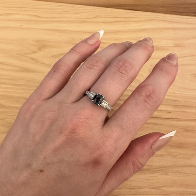 A spinel takes centre stage in a vivid hue at the centre of this solid 14K white gold ring, encircled by twenty-four...