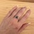 A spinel takes centre stage in a vivid hue at the centre of this solid 14K white gold ring, encircled by twenty-four...