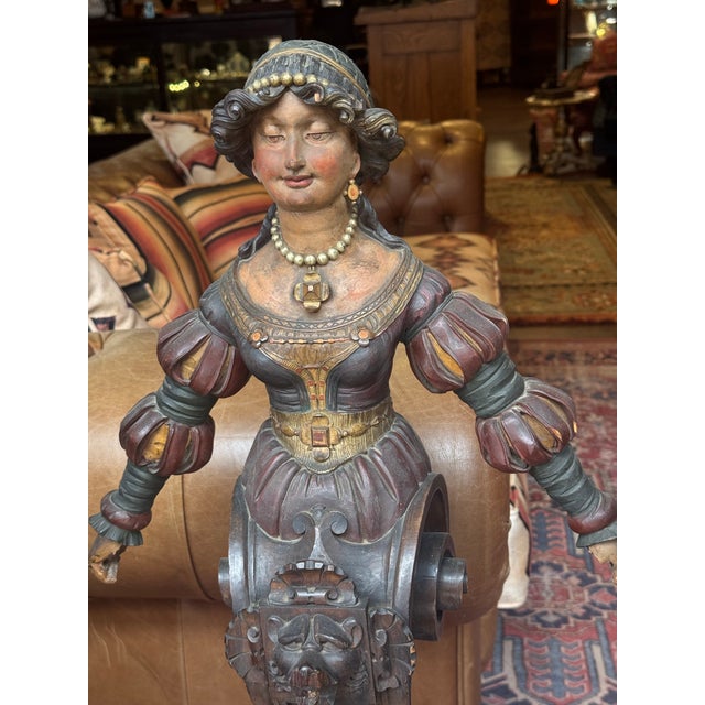 Antique 18th century or earlier European polychromed carved wooden female form with scroll work designed columnar base. It...