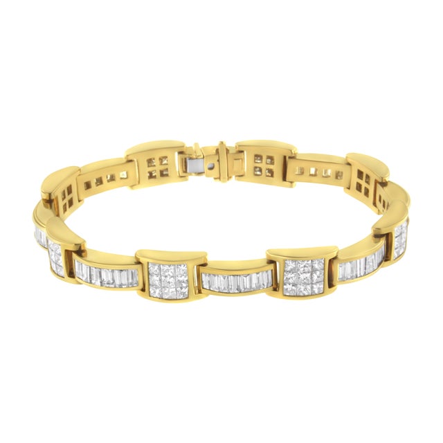 A glossy 14 karat yellow gold band is the perfect backdrop for over 10 carats of princess cut and baguette cut diamonds,...