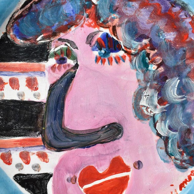 Circular ceramic platter in the manner of Jean Cocteau. This bold colorful piece features the portrait of a figurative...