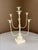 Vintage French-style painted metal candelabra with seven arms for taper candles. The color is ivory/off-white.