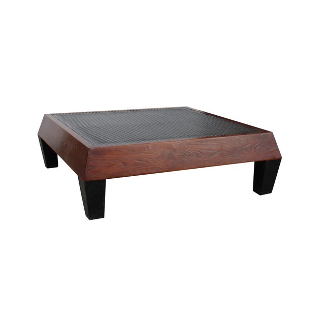 This low-profile square coffee table features a striking blend of rustic textures and clean, architectural lines. The...