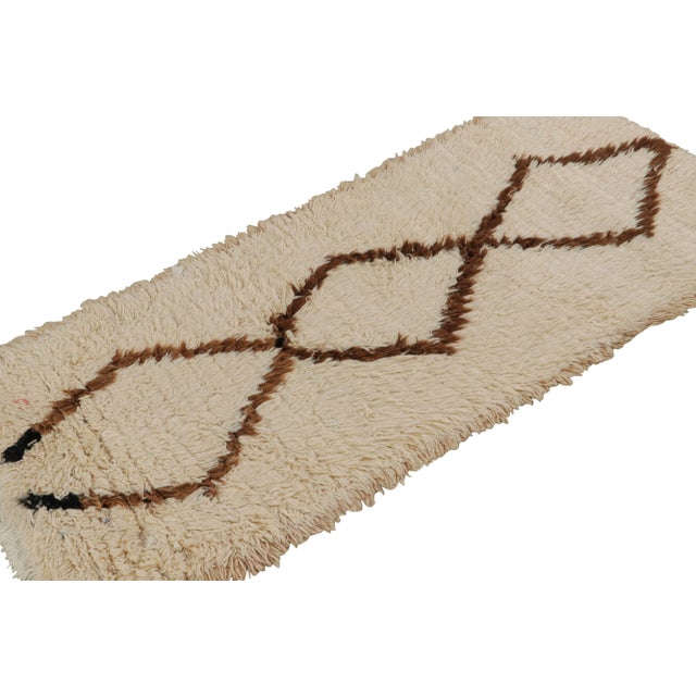 Hand-knotted in wool circa 1950-1960, this 2x6 vintage Moroccan runner rug in beige-brown with diamond medallions, hails...