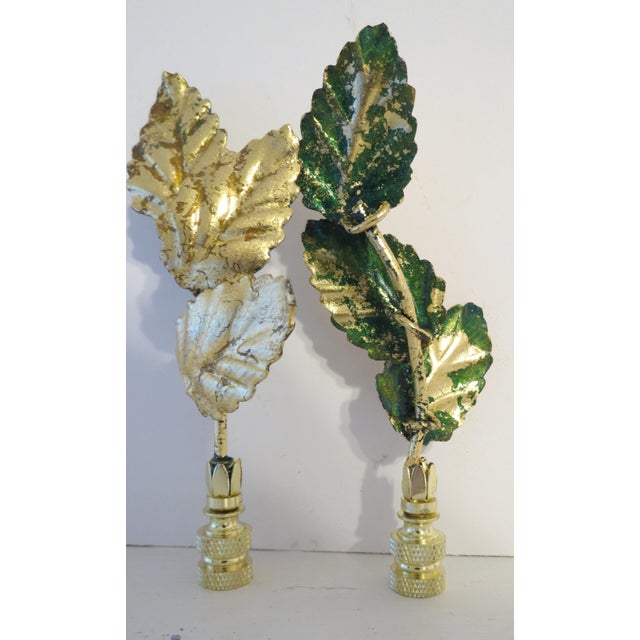 Unique pair of vintage Italian Gold Leaf Tole Finials set in brass bases. Triple set of leaves reaches upward to reflect...