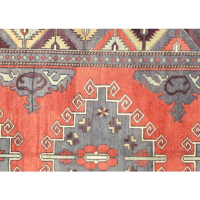 A vintage Turkish Oushak measuring 5'1" x 12'1", hand-woven with wool on wool foundation. This piece displays the region's...