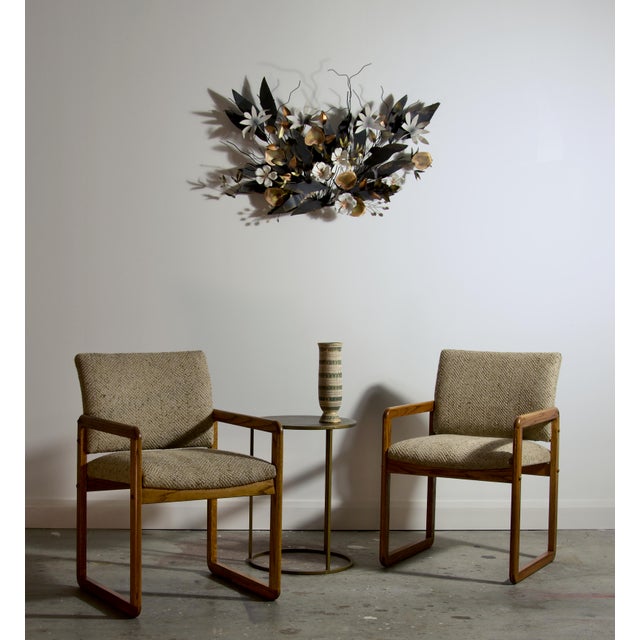 A striking pair of American armchairs built from solid oak with continuous loop side frames that carry the arm rail and...