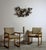 A striking pair of American armchairs built from solid oak with continuous loop side frames that carry the arm rail and...