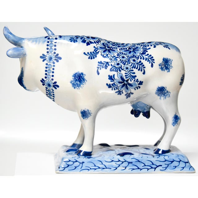 A finely painted large ceramic faience cow, decorated with underglaze blue floral motifs. Circa 1874 -1900, bearing the...