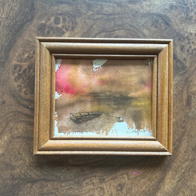 A quiet, meditative scene of a lone boat gently tethered to a buoy at the water’s edge. Rich, earthy tones blend into a...