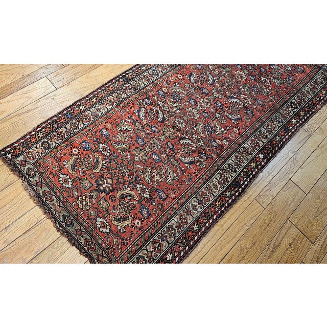 "A beautiful and rare 19th century Persian Farahan wide runner featuring the classic Herati pattern on a rich rust-red...