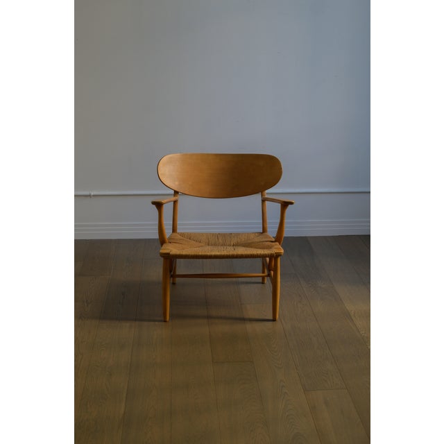 1951 HANS J. WEGNER Lounge Chair, model no. CH-22 manufactured by Carl Hansen & Søn, Denmark. Oak frame with rush seat. In...