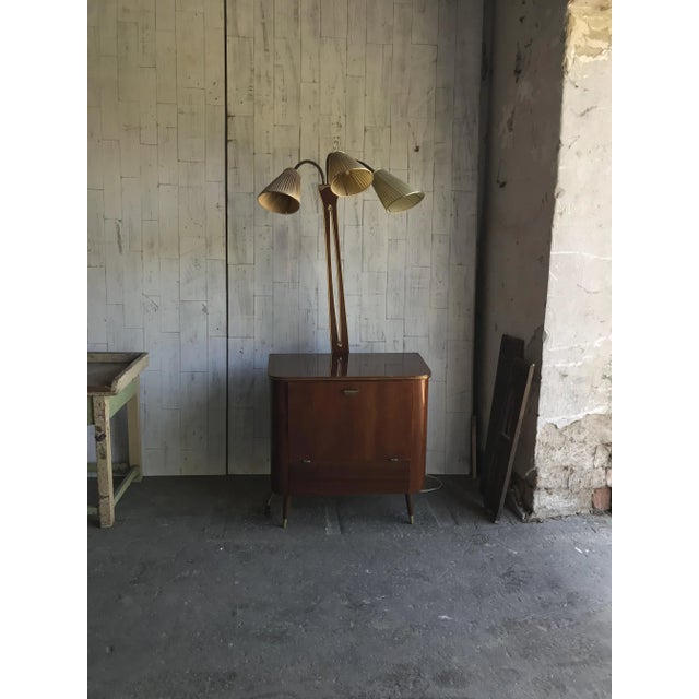 This Art Deco style drinks cabinet dates from the 1950s. It is made of walnut and brass and comes with a lamp. The lamp is...