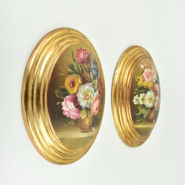 Beautiful still life set of paintings on convex oval wood panels. Both pieces depict abundant flowers in a vase. The...