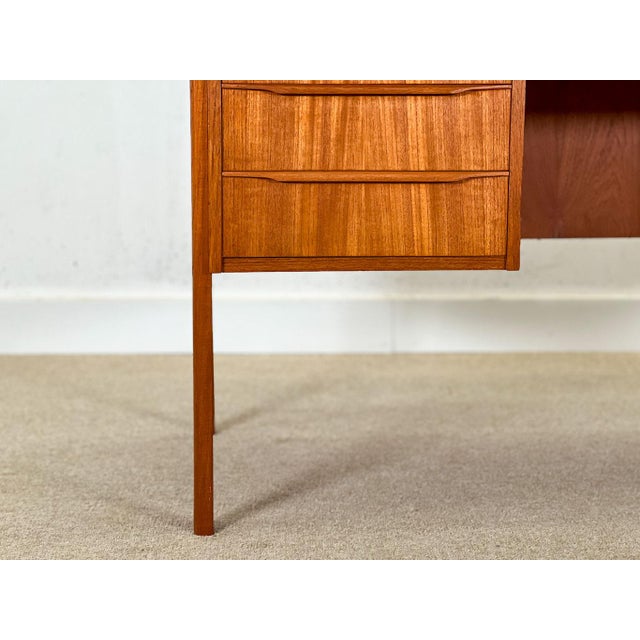 This impressive Danish desk, handcrafted in the 1960s from richly grained teak, showcases a beautifully designed...