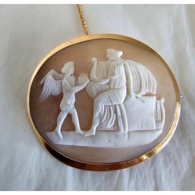 A finely carved Victorian shell cameo brooch dating to circa 1880–1890, depicting an elegant Neoclassical scene of a...