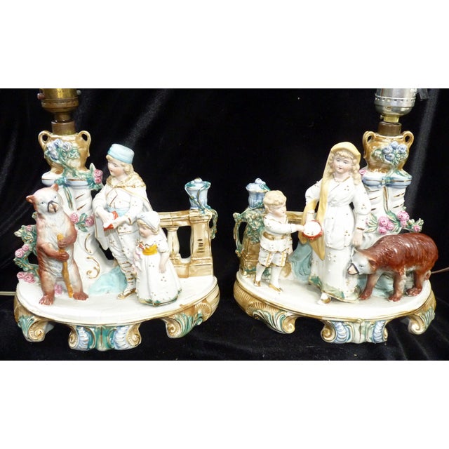 This exceptional pair of 15-inch German bisque lamps by Gebrüder Heubach (circa 1900) captures a rare two-part "Circus...