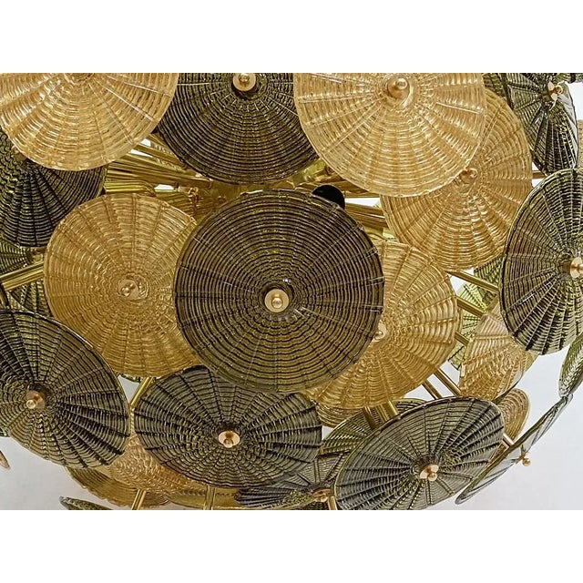 The large gold and olive green colored glass disks make up this Murano chandelier from the 2000. A Classic Sputnik from...