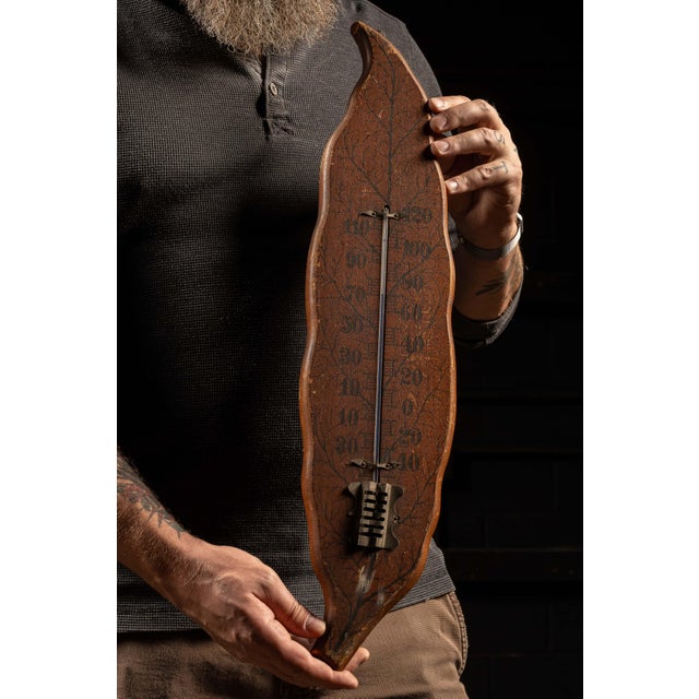 c. early 1900s; Wooden Thermometer in Tobacco Leaf Form Antique wall thermometer mounted on a hand carved and stained...