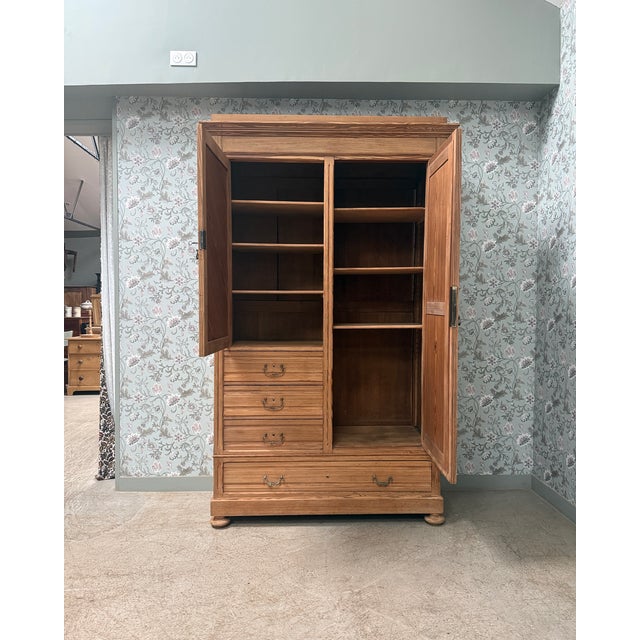 A large antique wardrobe from the late 19th century, distinguished by its asymmetrical front combining a door with...