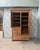 A large antique wardrobe from the late 19th century, distinguished by its asymmetrical front combining a door with...