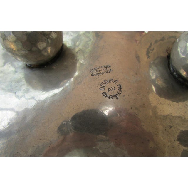 The artist's signature and the hallmark guaranteeing the purity of the tin are visible under the base, confirming its...