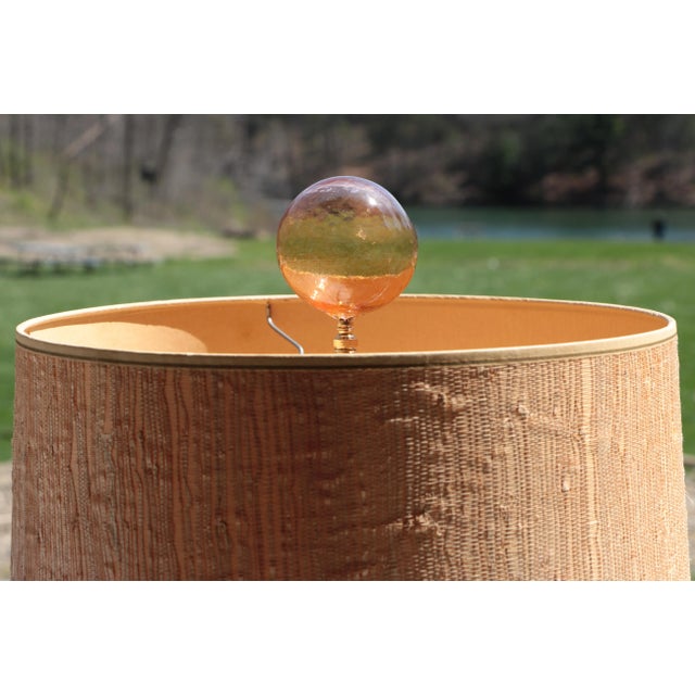 Single lamp finial crafted from a large glass bubble in translucent peach topping a golden brass swivel base....