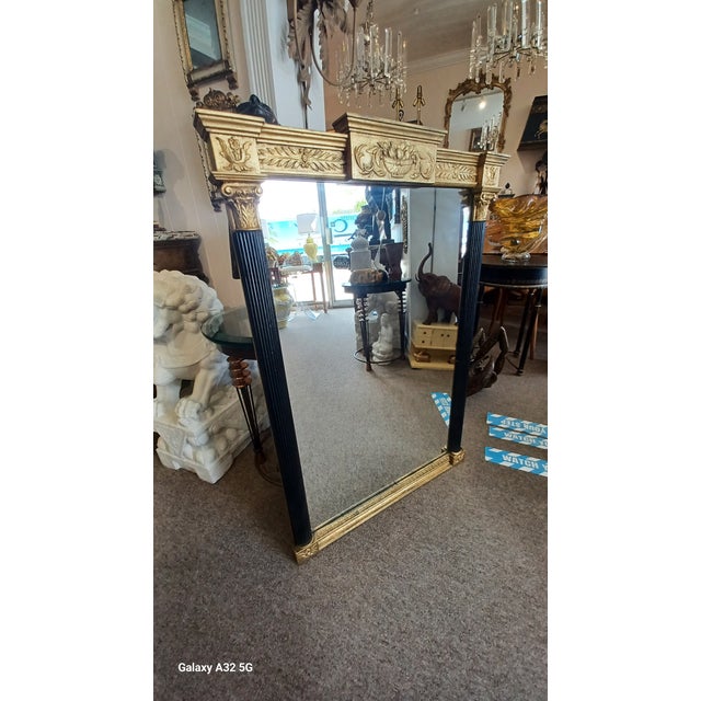 Vintage neoclassical style black and gilt wall mirror.
