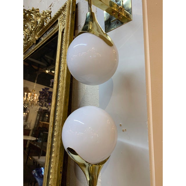 Very sleek set of modern gilt brass and Murano glass sconces. Each sconce has 2 glass balls on a shining brass base. A...