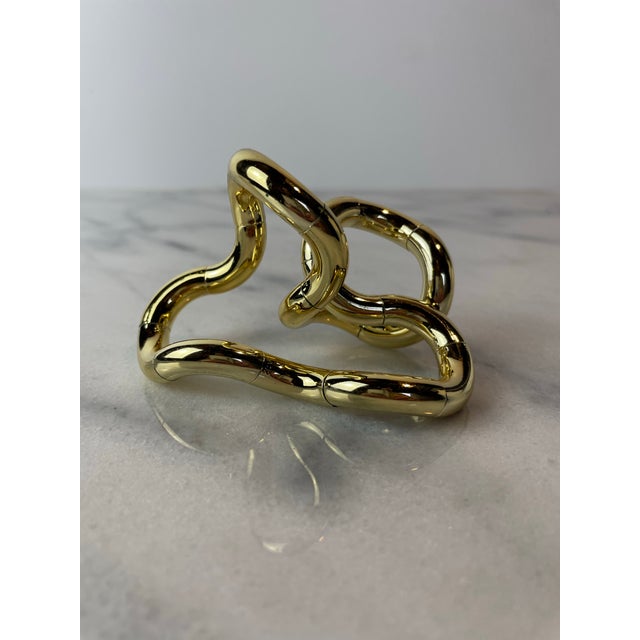 A miniature approx 3” mini tangle sculpture in gold. Based on the Tibetan infiny knot, this Richard X. Zawitz sculpture...