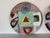 A dynamic pair of vintage handmade ceramic wall art plates by artist Larry H., dated 6.82. Each plate showcases a unique...