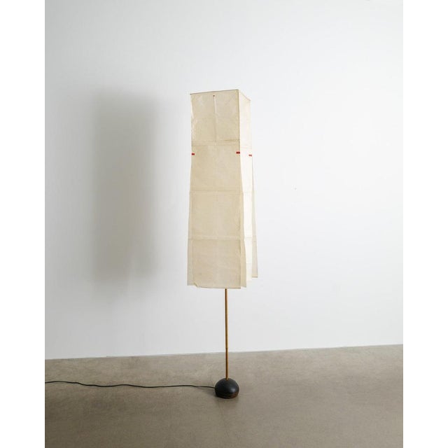 A very rare and early japanese mid century modern floor lamp with the "l1" shade in patinated washi paper with red details...