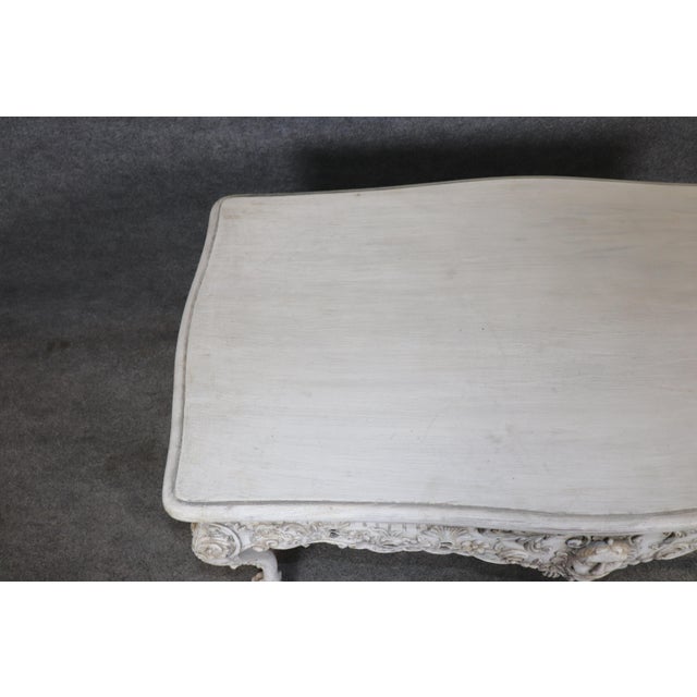 This striking Georgian style walnut figural masque center table, finished in an aged distressed white painted surface,...
