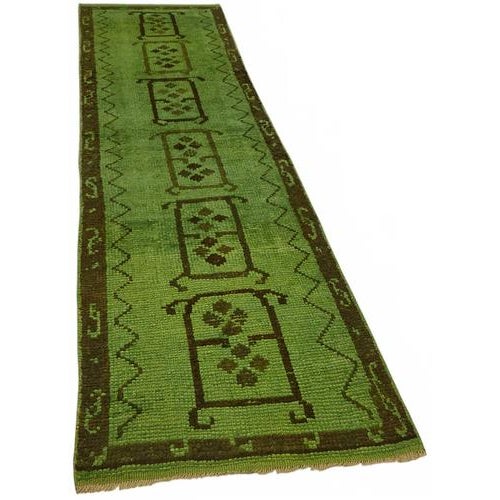 This exquisite runner rug is a rare example of tribal craftsmanship, hand-knotted by the women of the Herki tribe during...