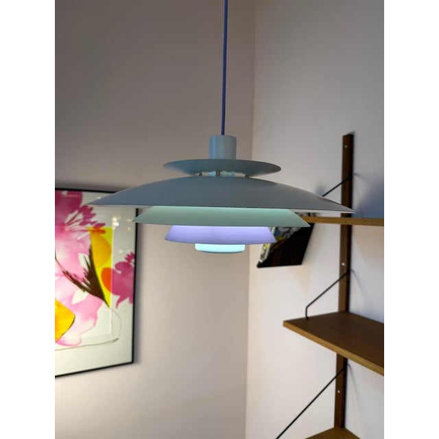 This slatted lamp from Formlight in Denmark skillfully plays with form and color: Five layered slats combine to create a...