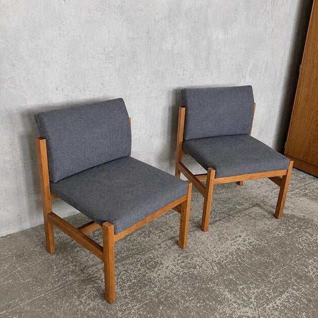 A characterful pair of 1970s Brutalist lounge chairs with chunky pine and oak frames, low relaxed proportions and a...